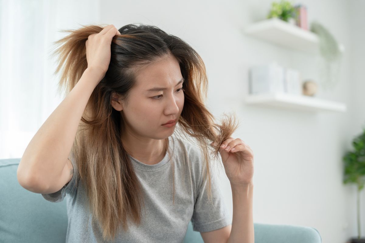 woman looking at damaged hair