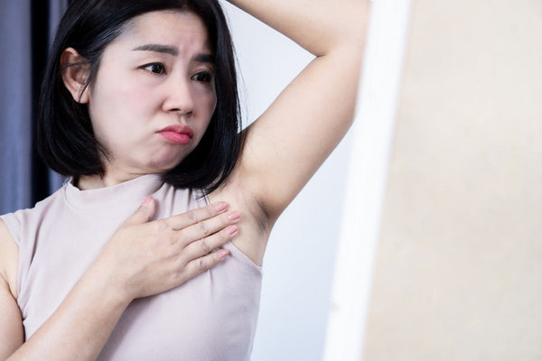 Worried Woman Looking at Dark Armpit on a Mirror